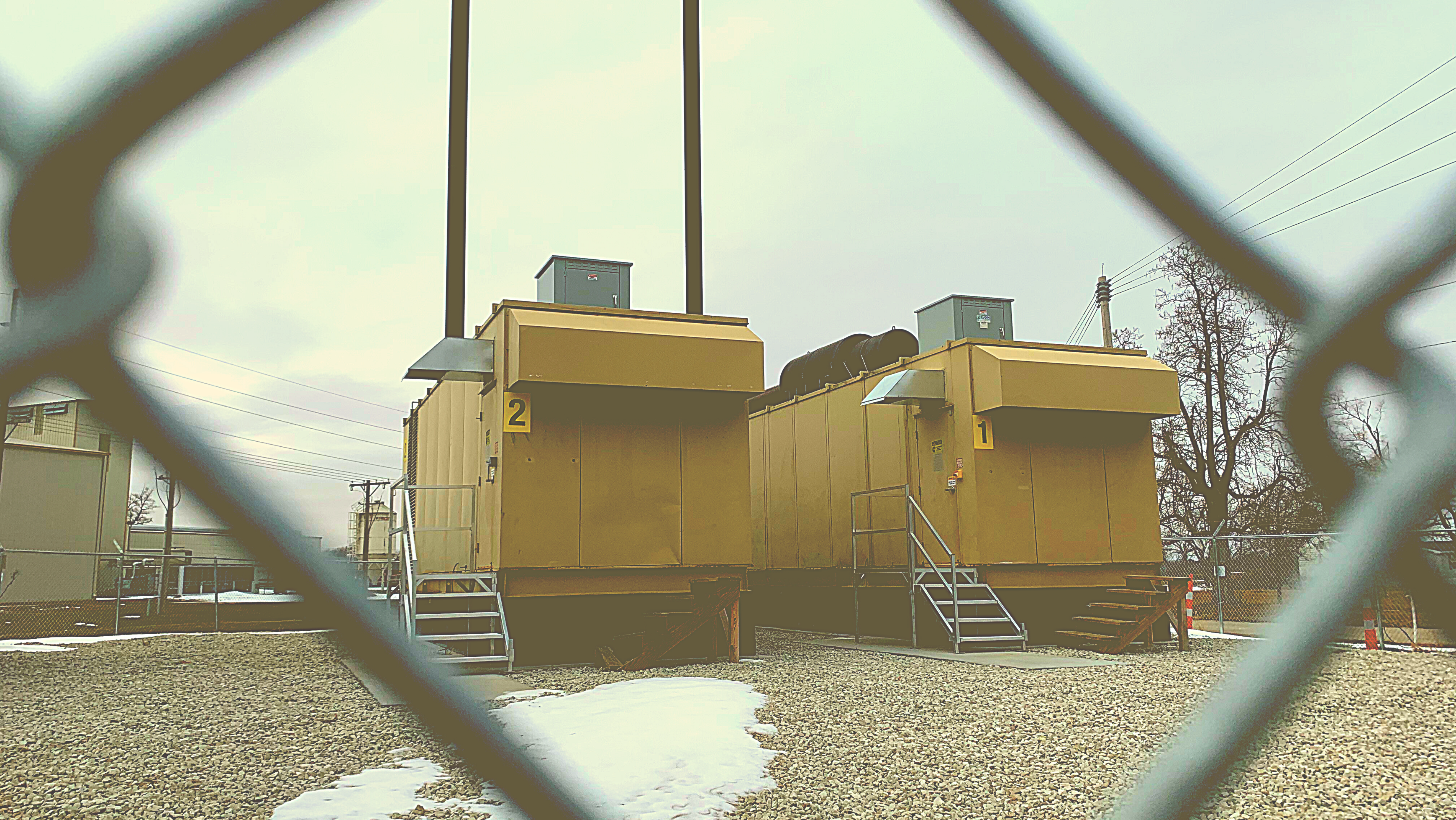 Photo of two electrical generators behind a fence