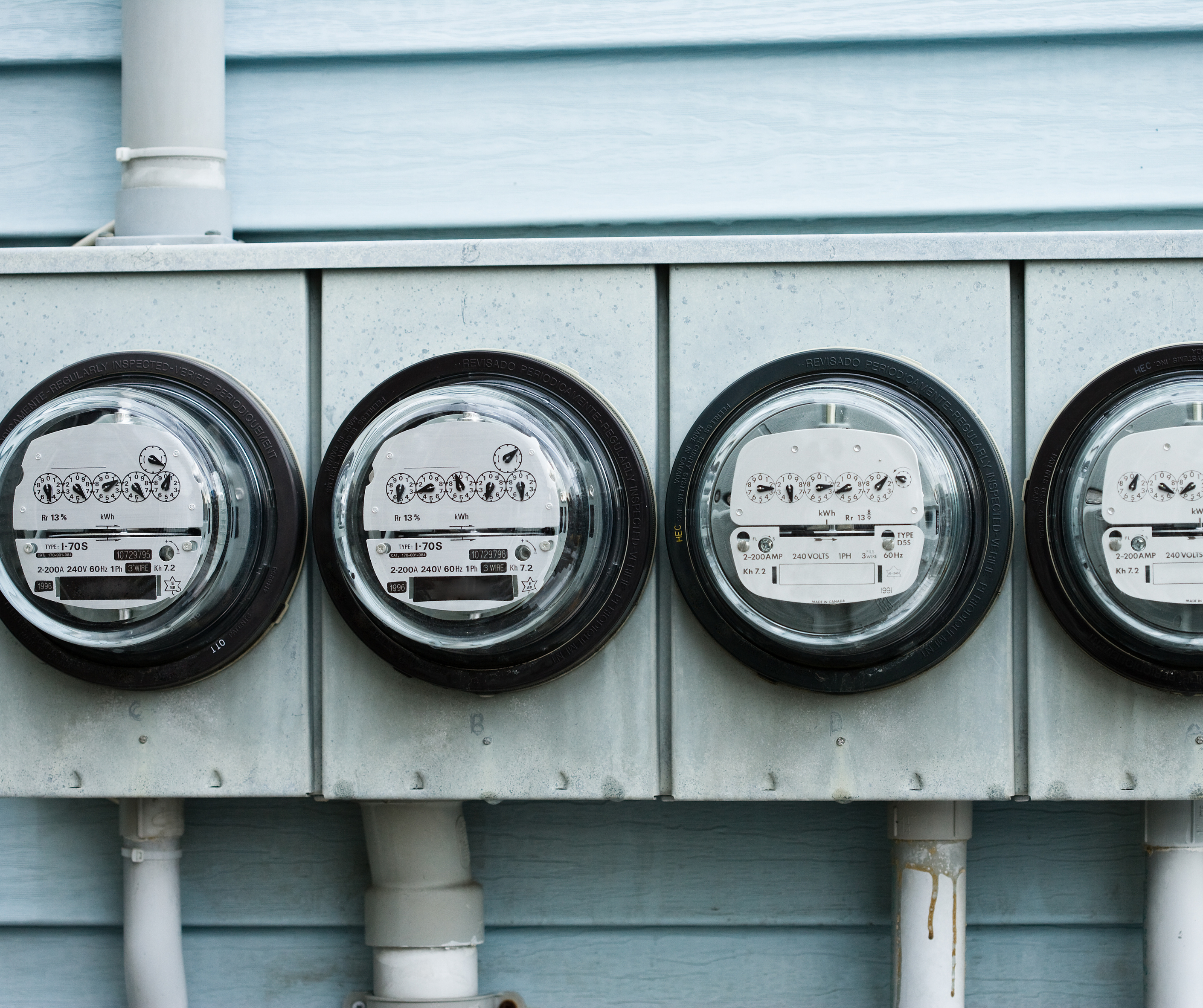 utility meters lined up on a house